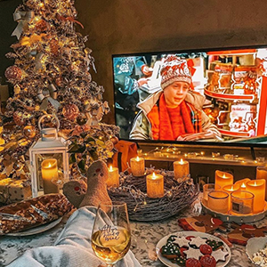 Instagram - Photo taken from Instagram of scenic living room with fully decorated Christmas tree, candles, a tray of cookies, and "Home Alone" playing on a big TV. Image is NOT mine, image is an edit from the instagram account christmas.idea and the instagram account @fashioninmysoul .